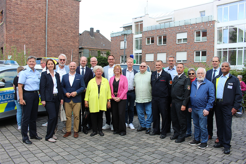 Gruppenbild und in Teilen ein Streifenwagen auf der linken Seite