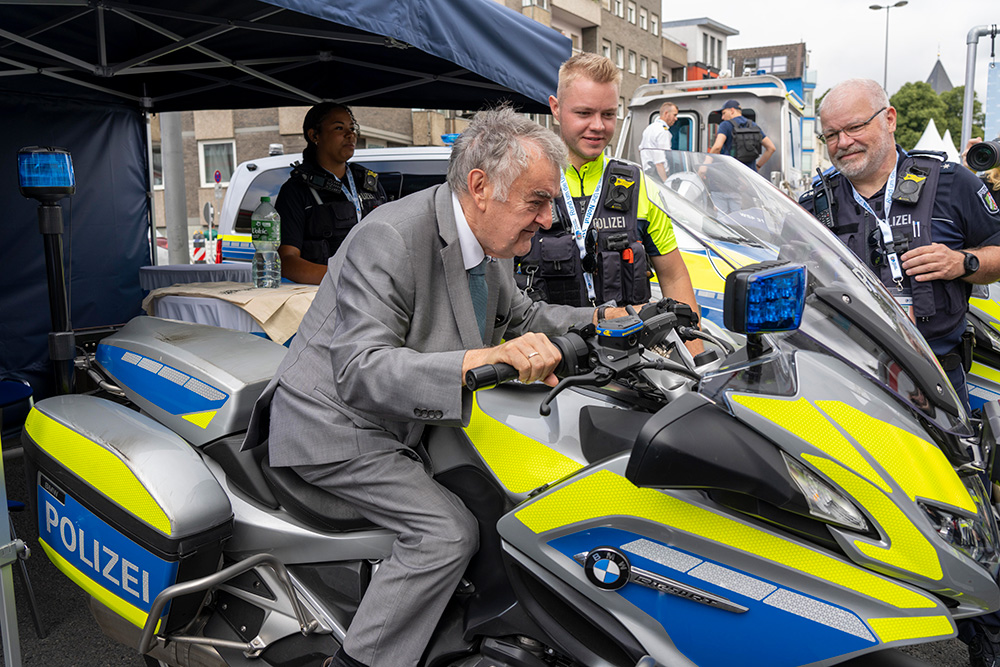 Minister Reul sitzt auf einem Polizeimotorrad