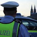 Police officer in front of patrol car in Cologne