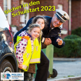 Ein Polizist, der Kindern über die Straße hilft und auf Gefahren hinweist.