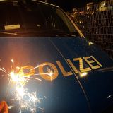 Schriftzug Polizei eines Streifenwagens mit einer Wunderkerze