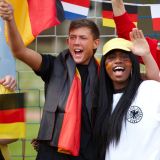 Jubelnde Fußballfans im Stadion internationale Flaggen