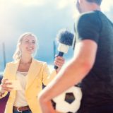 Reporterin im Interview mit Fußballer im Stadion