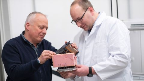 Felix Baum (left) and Mathias Teroerde attach a pistol to a suitably shaped piece of foam so that the weapon can be examined from all sides.