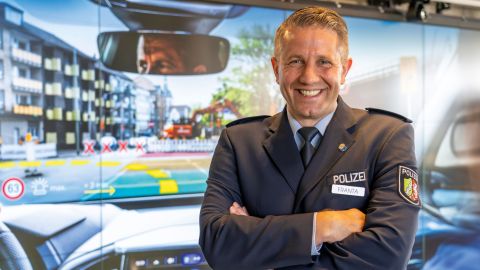 Thomas Franta from the LZPD NRW stands in front of the simulated cockpit of the patrol car of the future