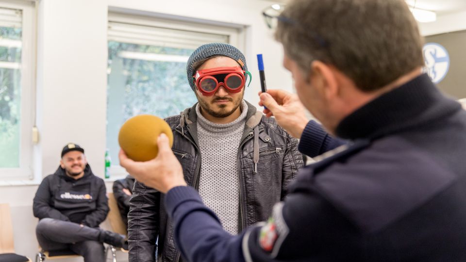 Polizeihauptkommissar Carsten Jahns simuliert mit einer Rauschbrille das Verhalten eines Autofahrers unter dem Einfluss von Alkohol und Drogen